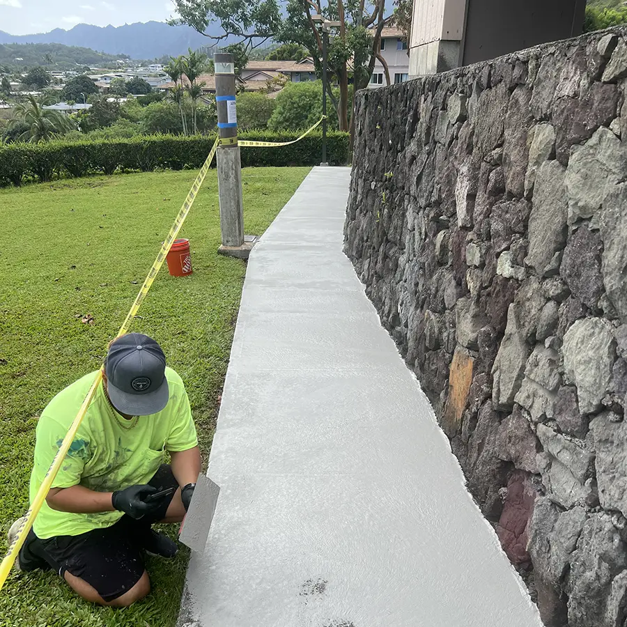 Concreate Oahu employee installing concrete coating to backyard path