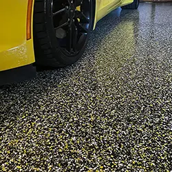 Flake garage coating with car tire visible