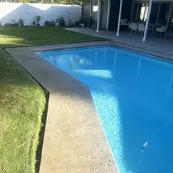 Pool deck with thin finish concrete coating