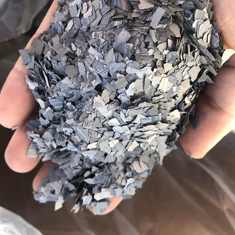 Close up of a hand holding flakes for use in epoxy flooring