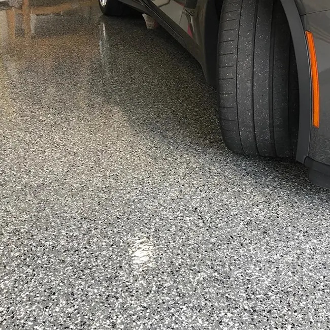 Flake garage coating with car tire visible